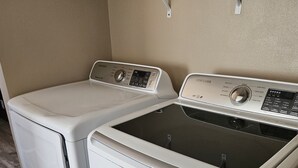 A laundry room with two white front-loading washing machines. - Movie House (Thompson)