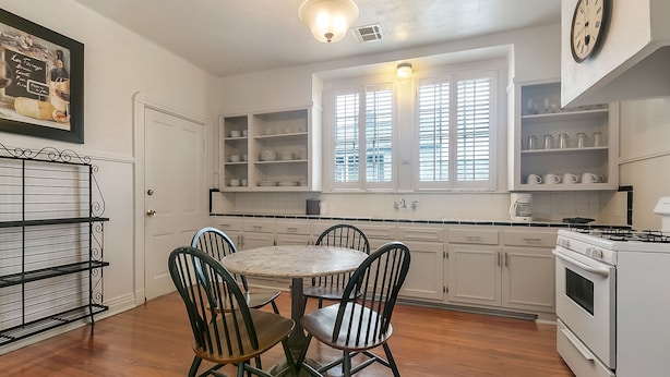 A kitchen with white cabinets, a round table with chairs, a stove, and a window with blinds. - Walk to all the French Quarter attractions.  A great space to enjoy NOLA (New Orleans)