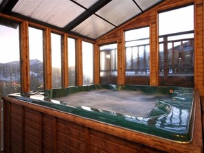 Relax in a hot tub surrounded by a serene mountain view.