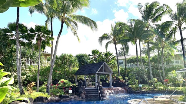 A pool area with lounge chairs, a small waterfall, and tropical vegetation. - Beautifully Furnished-Great for families 3 Bed, 2 1/2 Bath Nihilani, Princeville (Princeville)
