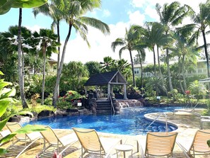 A pool area with lounge chairs, a small waterfall feature, and tropical vegetation. - Beautifully Furnished-Great for families 3 Bed, 2 1/2 Bath Nihilani, Princeville (Princeville)
