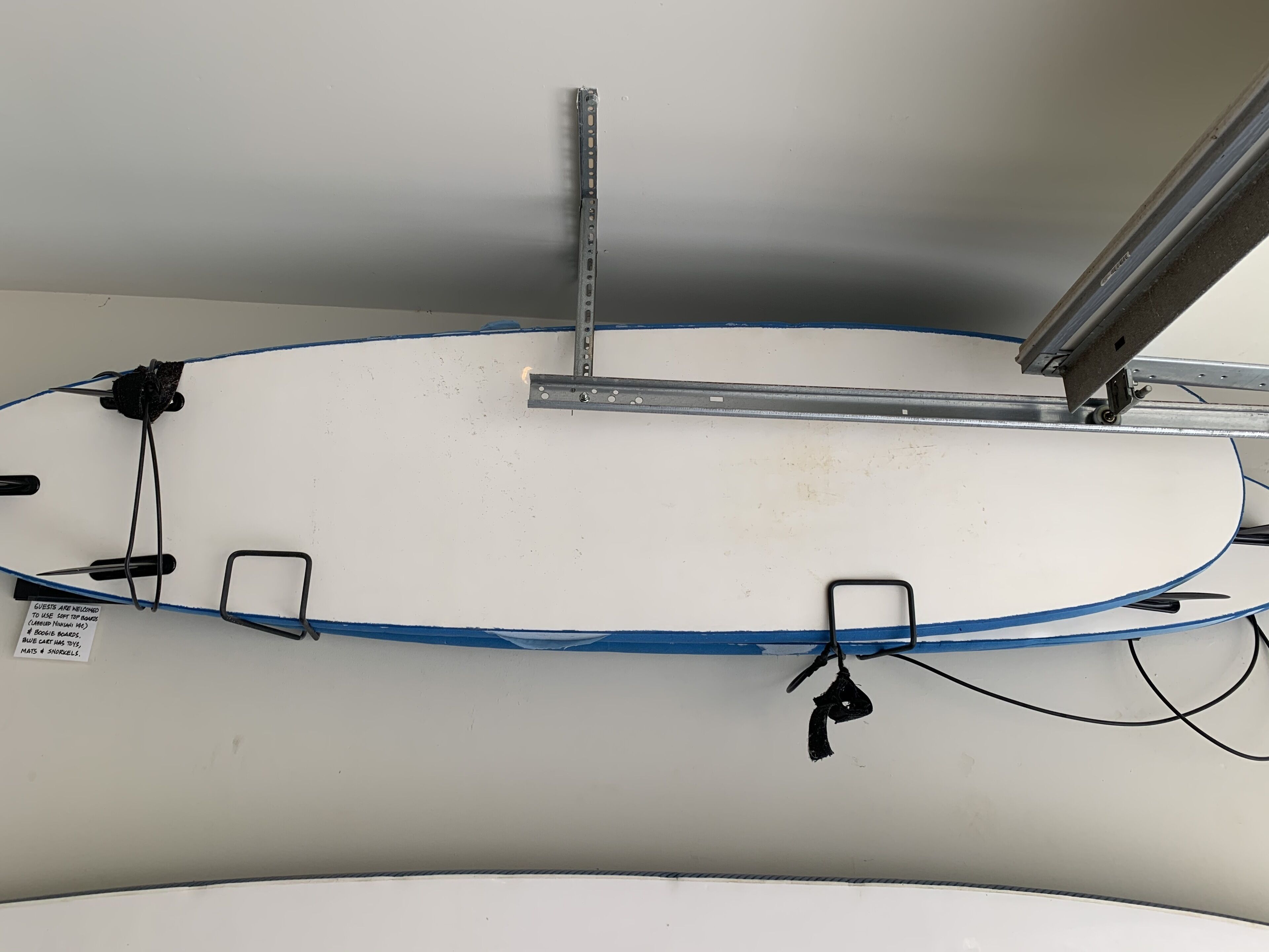 Un plafond muni d’une équerre métallique et d’un câble bleu qui le traverse.