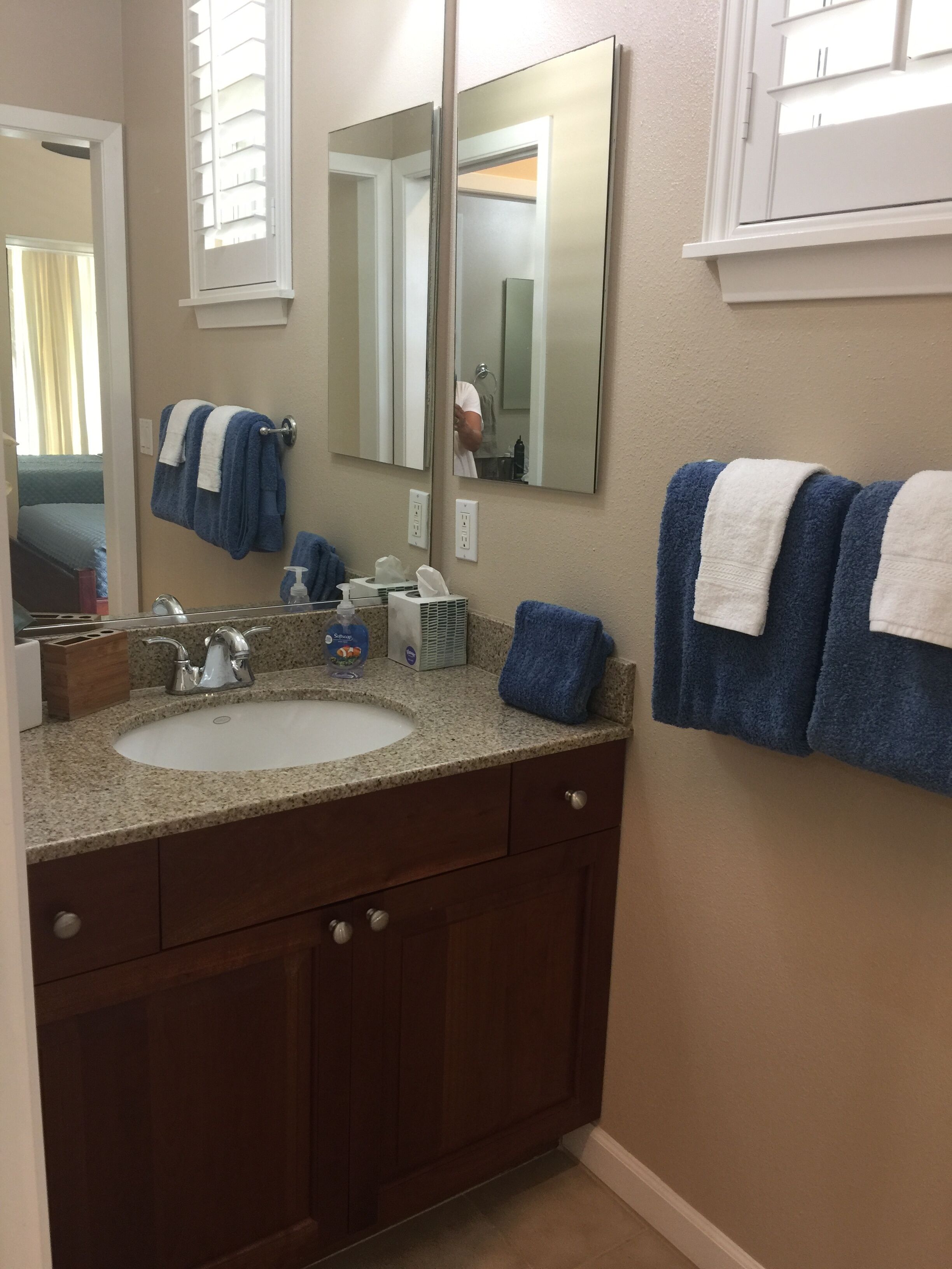 A bathroom with a sink, mirror, and towel rack.