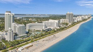 A coastal cityscape with high-rise hotels, a beachfront, and a marina.