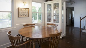 A dining room with a wooden table and chairs, a cabinet with glass doors, and a framed quote on the wall. - 3 acre Lake, Farm Animals Petting Zoo, Horses and Horseback Riding, Room to roam (Brownsburg)