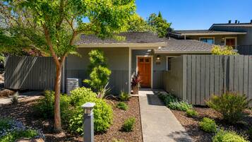 A residential property with a front yard, a wooden door, and a satellite dish.