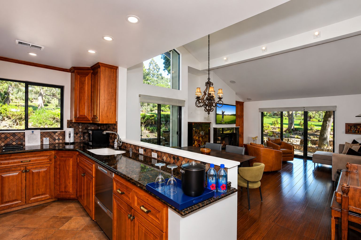 Una cocina amplia con armarios de madera, una isla grande y un comedor con vistas al exterior.