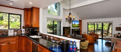 Una cocina amplia con armarios de madera, una isla grande y un comedor con vistas al exterior.