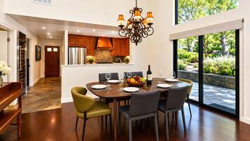 A dining area with a wooden table, chairs, and a chandelier.