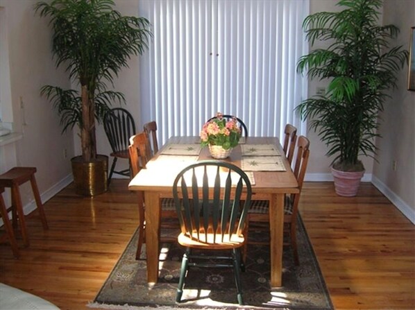 Enjoy meals in this dining area with a table for four, surrounded by comfortable chairs and lush greenery.