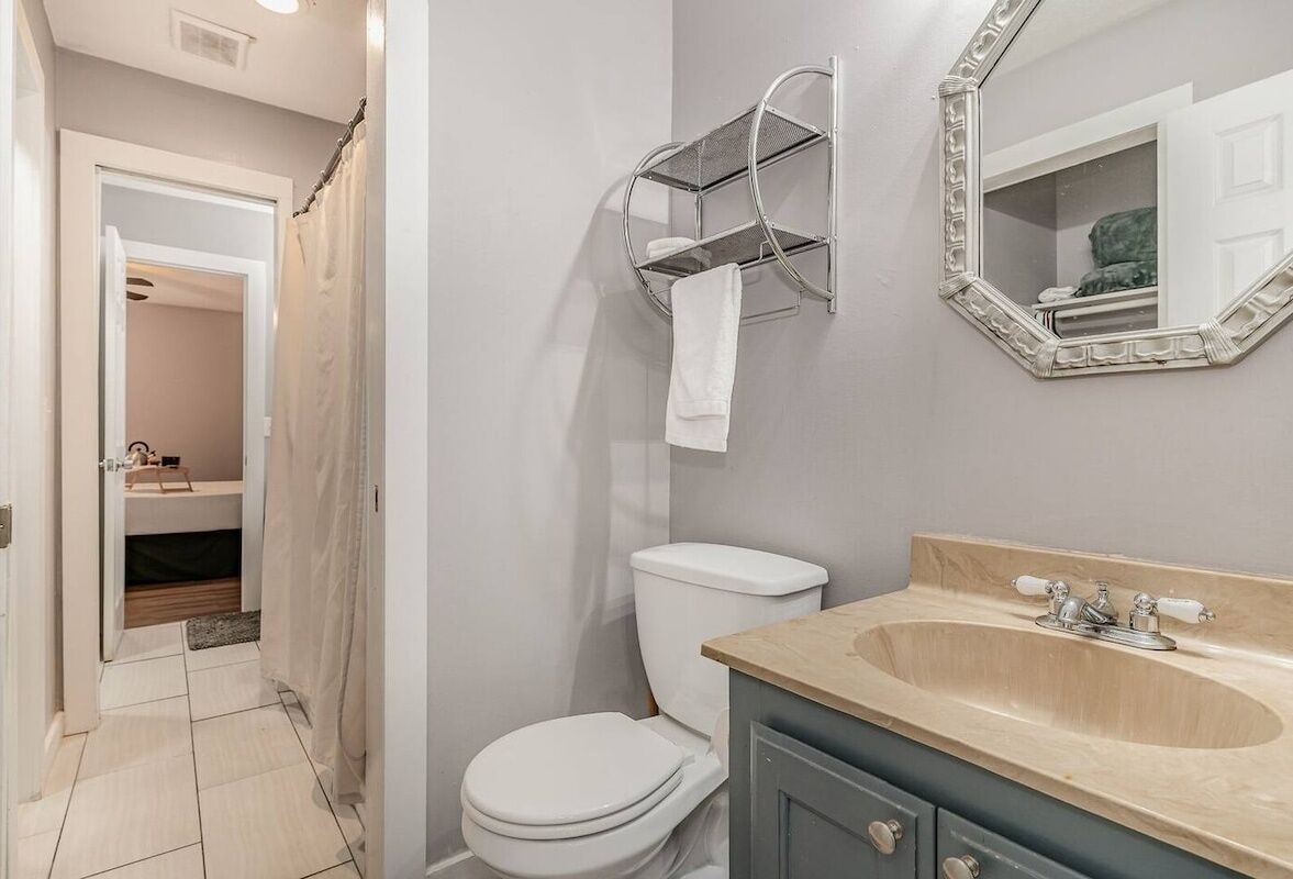 Een badkamer met toilet, wastafel en handdoekhouder.