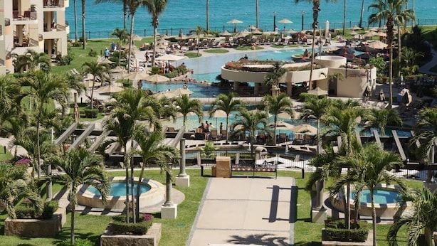 A resort with multiple swimming pools, palm trees, and a view of the ocean. - UNBELIEVABLE VIEWS-EXTRA LARGE BALCONY FOUR LOUNGE CHAIRS 3 KING BEDS (Cabo San Lucas)