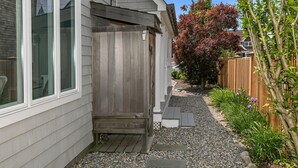 A residential property with a wooden deck, a gravel pathway, and a garden with various plants and a wooden fence. - Newly renovated upscale Beach House  (Bay Head)