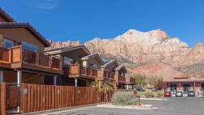 A row of cabins with balconies, set against a backdrop of red rock mountains. - Springdale Townhome 1 (Springdale)