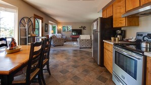 Una cocina amplia con una estufa grande, armarios de madera y un comedor con mesa y sillas.