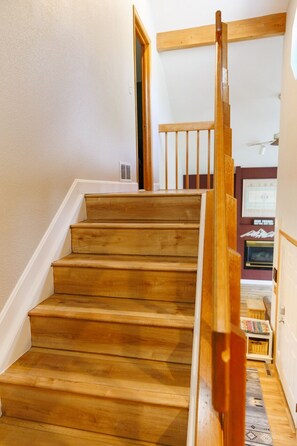 Una escalera de madera con barandilla que lleva a un piso superior.