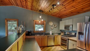 Una cucina moderna con mobili in legno, elettrodomestici in acciaio inossidabile e una grande isola.