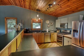 Una cocina moderna con armarios de madera, electrodomésticos de acero inoxidable y una isla grande.