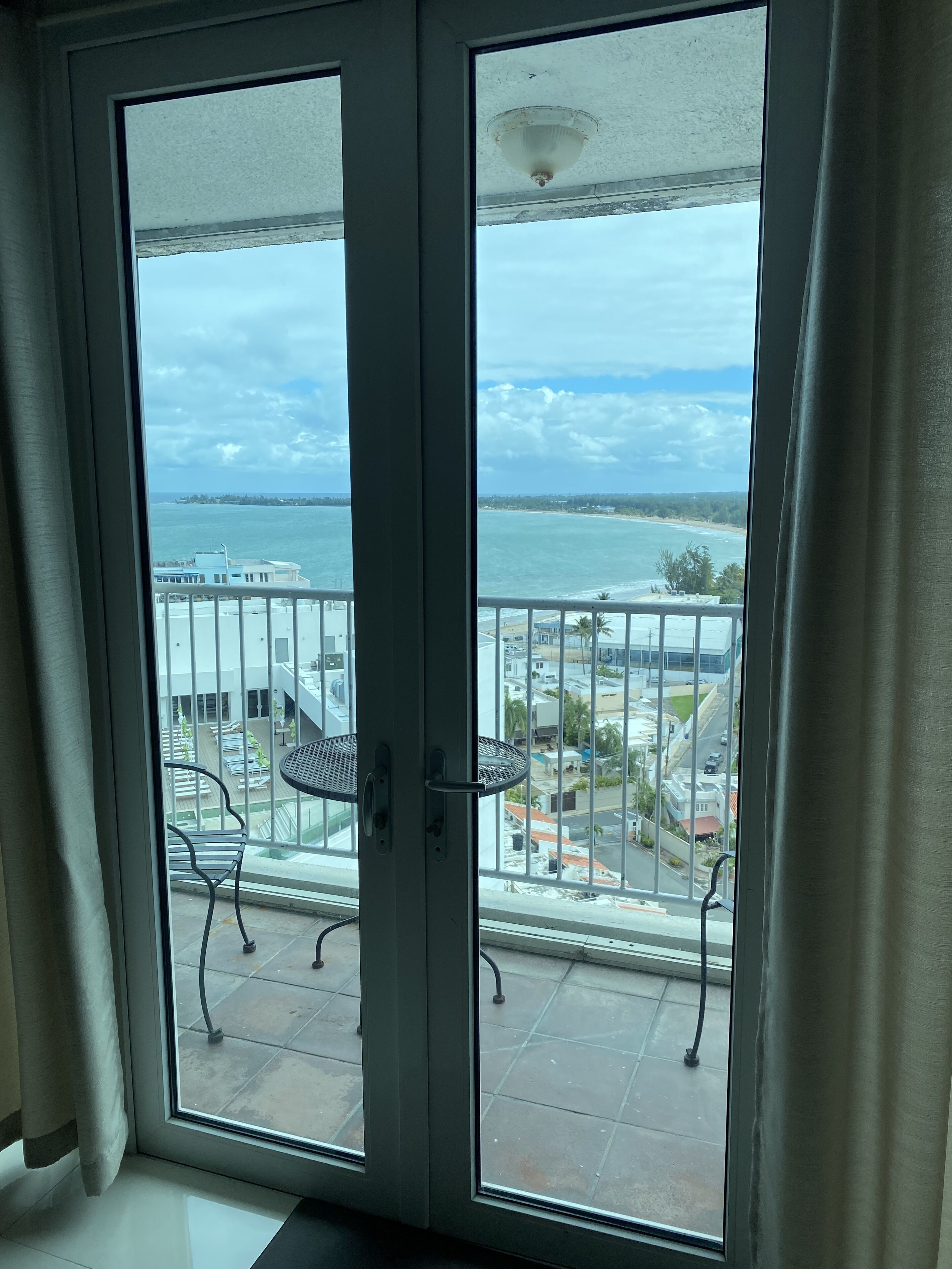 Een balkon met uitzicht op zee en gebouwen.