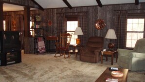 A living room with a fireplace, a television, and a bookshelf.