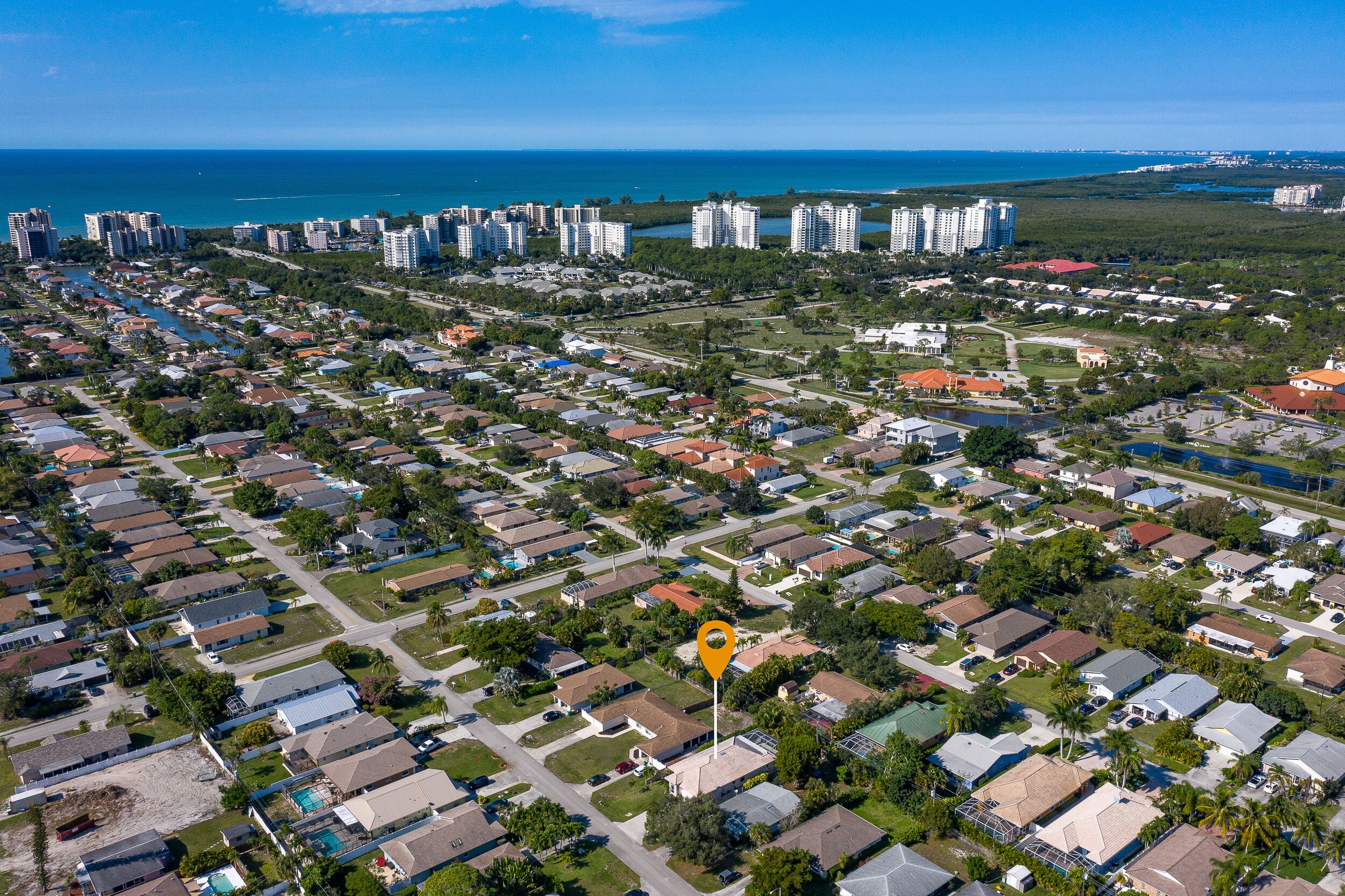 An aerial view of a residential area with multiple-story buildings, roads, and greenery.