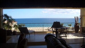 A balcony with a view of the ocean, a table with chairs, and a sofa. - Las Mananitas, Fifth Floor, 3 Bedroom Villa, Oceanfront, HUGE Balcony.  (San Jose Del Cabo)