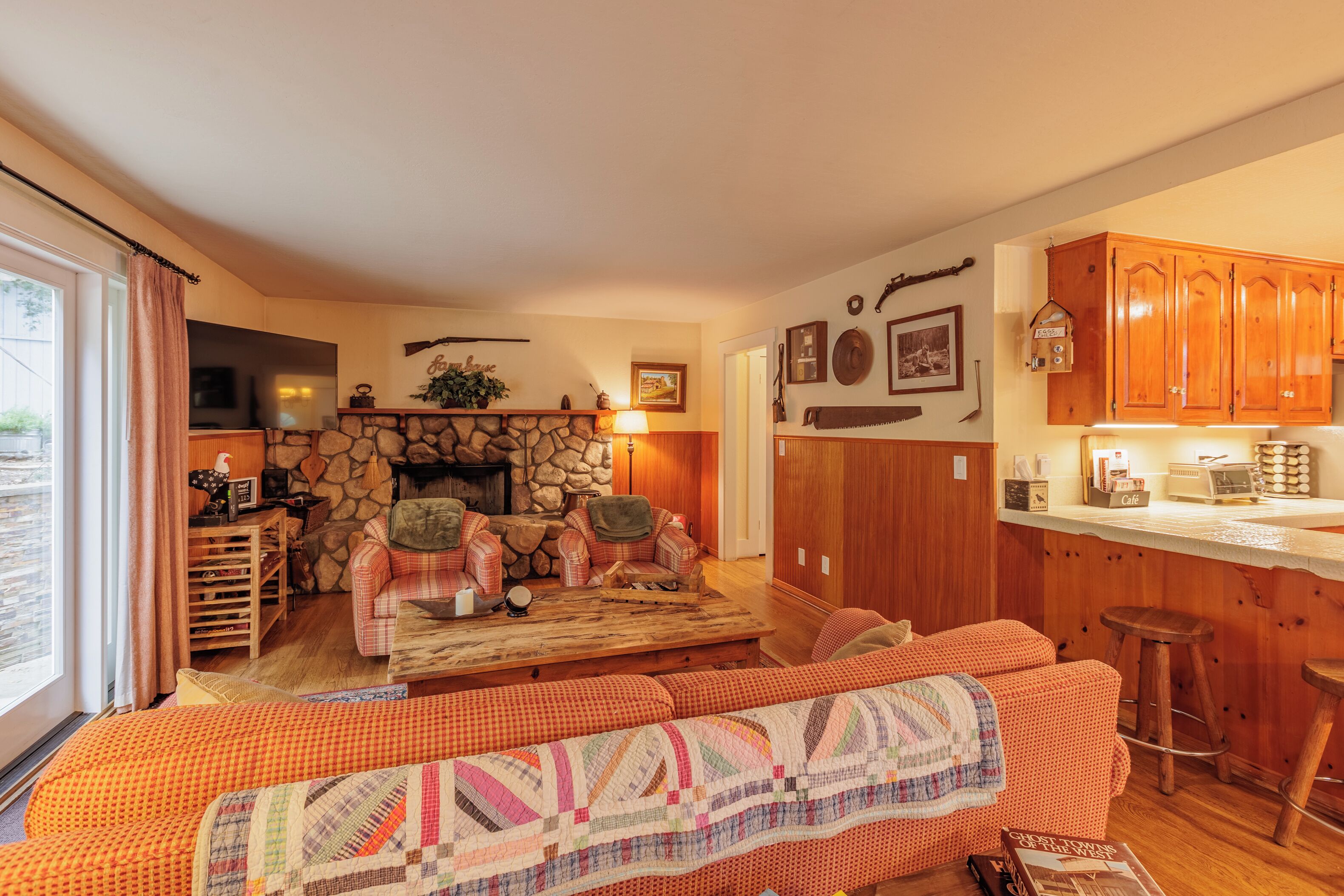 Ein gemütliches Wohnzimmer mit Kamin, Steinwand und Holzmöbeln.