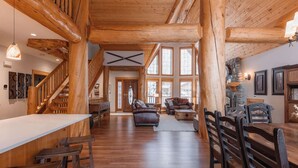 A spacious interior with a wooden staircase, a dining area, and a cozy seating area with a fireplace. - The Stemwinder Chalet by Simply Kimberley (Kimberley)