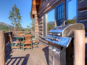 A wooden deck with a grill, chairs, and a table. - Big Sky Vacation Rentals: PR Manitou 13 (Big Sky)