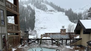 Zona de piscina con vista a una montaña nevada.
