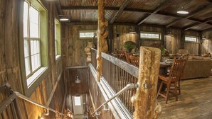 Un intérieur rustique en bois, avec un escalier, un coin repas et un espace détente.