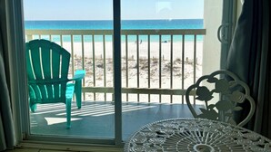 A room with a view of the beach, a green chair, a white table, and a decorative white tablecloth. - Third Floor Private Beach Terrace (Fort Walton Beach)