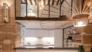 Una cucina moderna con pareti in mattoni a vista, un tavolo da pranzo in legno e un lampadario.