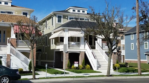 Stunning two-story home with a charming front staircase and second-floor balcony.
