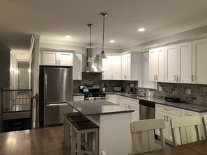 Enjoy cooking in this well-equipped kitchen with a central island, stainless steel appliances, and ample countertop space.
