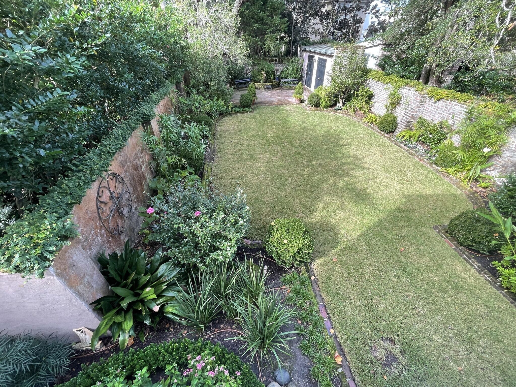 Un jardín bien cuidado con diversas plantas y un césped impecable.