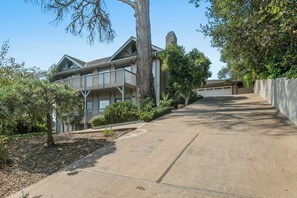 A two-story residential building with a garage, a covered driveway, and mature trees. - Valley Views: Newly Remodeled 4br 4ba with Spectacular Valley Views (Carmel)