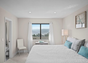 A bedroom with a large bed, a chair, a small table, a window with curtains, and a lamp. - Valley Views: Newly Remodeled 4br 4ba with Spectacular Valley Views (Carmel)