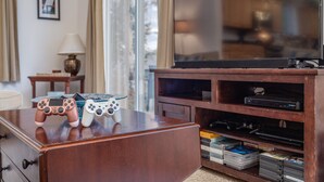 A wooden entertainment center with a television and video game controllers on top.