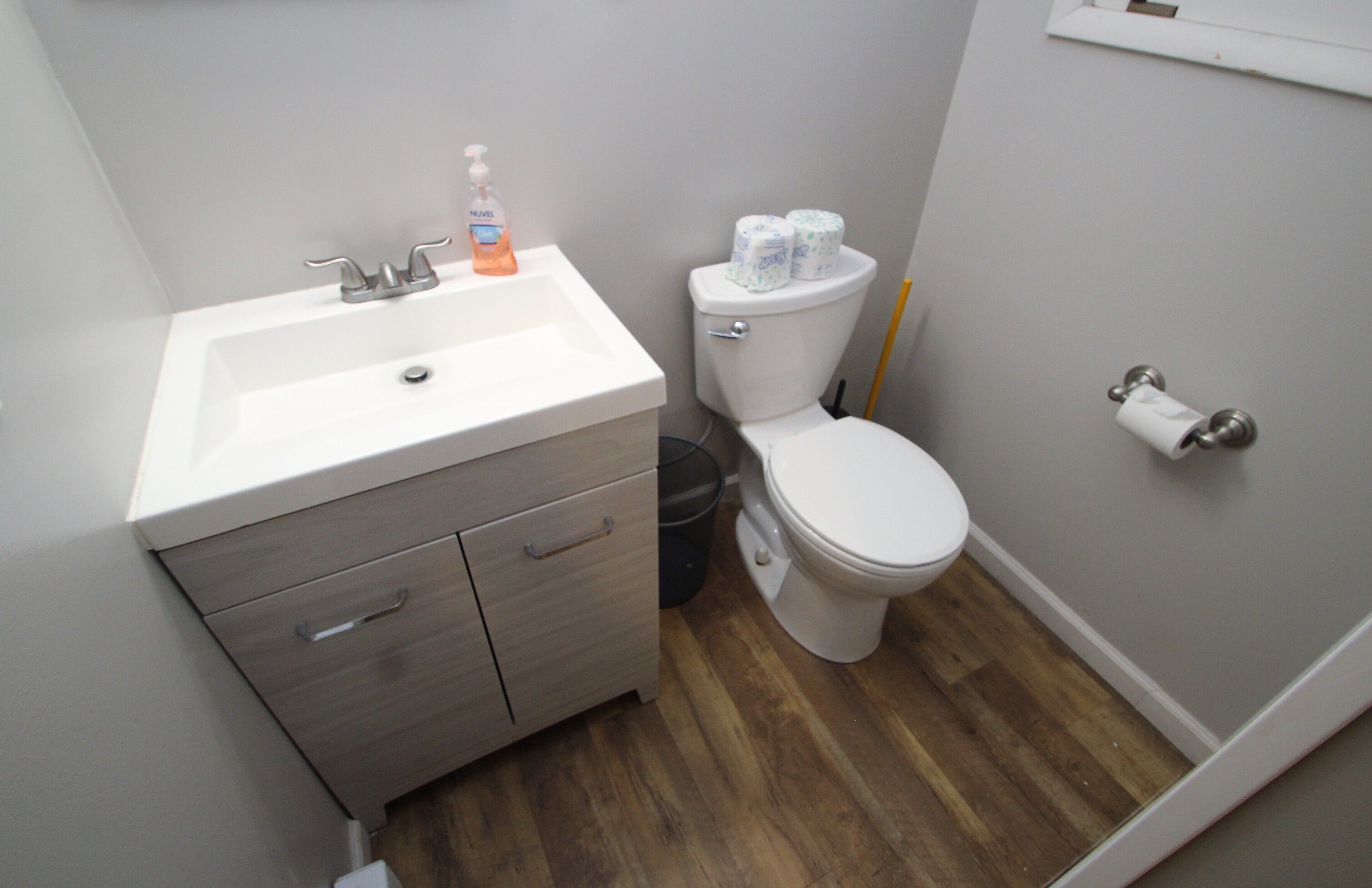 A small bathroom with a sink, toilet, and a trash can.