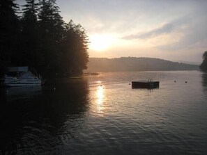 A calm lake at sunrise with a dock and a boat on the left. - Loon Lake, Chestertown - spotless, bright chalet for  6-8, close to Public Beach (Chestertown)