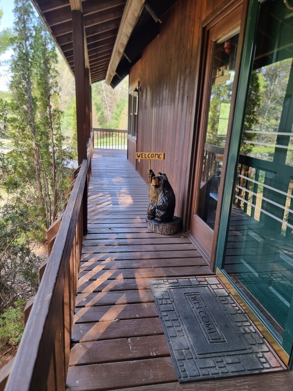 A wooden porch with a welcome sign, a doormat, and a statue of a bear. - Loon Lake, Chestertown - spotless, bright chalet for  6-8, close to Public Beach (Chestertown)