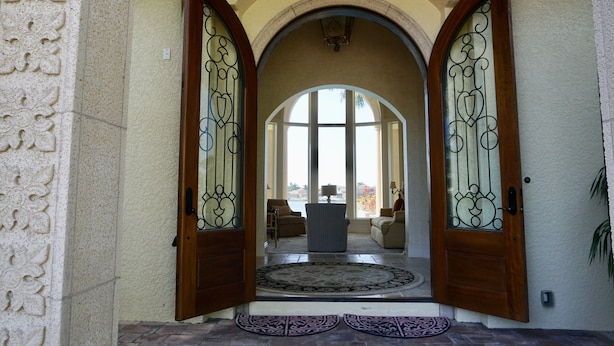 A grand entrance with a large arched doorway, a decorative rug, and a view of the interior. - Waterfront Paradise in Marco Island (Marco Island)