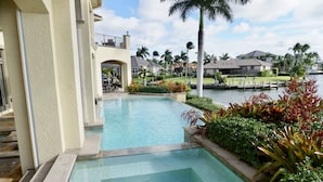 A swimming pool with a view of a residential area and a dock. - Waterfront Paradise in Marco Island (Marco Island)