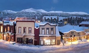 A snow-covered town with historic buildings and a mountain in the background.