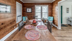 Ein Esszimmer mit Holztisch, Stühlen und einem zentralen Dekorationsobjekt.