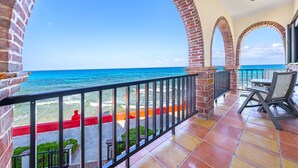 Un balcon offrant une vue sur l’océan, agrémenté d’arches en briques et doté d’un sol carrelé.
