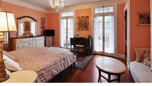 Une chambre à coucher avec un grand lit, un bureau, une chaise et un lustre.