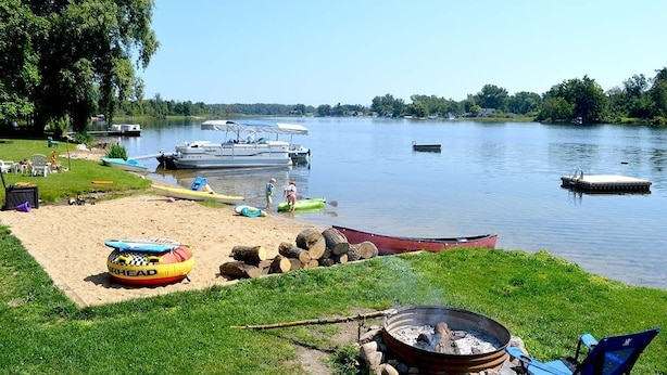 Un cadre idyllique au bord du lac, avec des bateaux, un foyer et des espaces de détente en plein air.