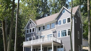 Une maison à deux étages dotée d’un balcon et d’un porche abrité.
